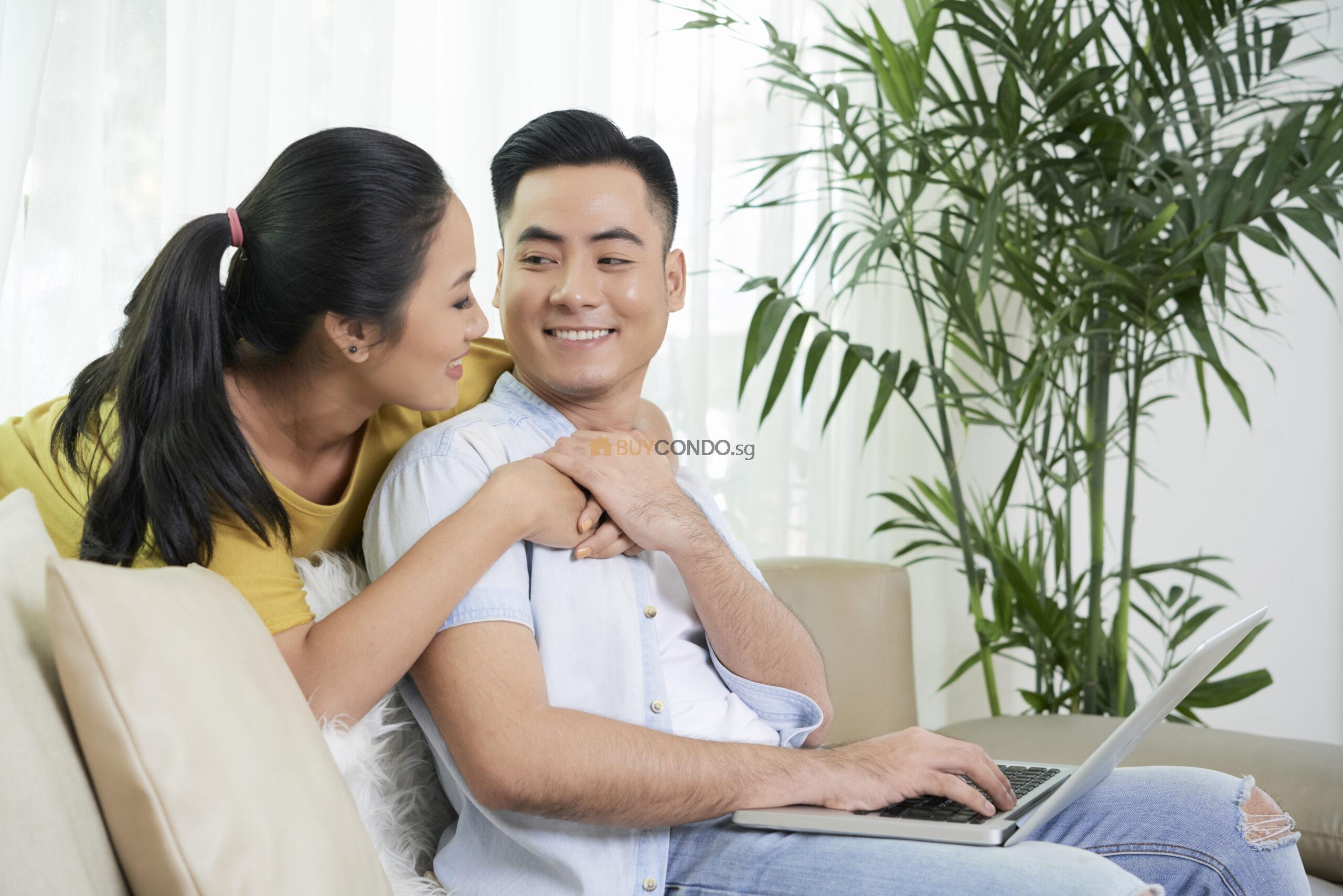 relaxing couple love couch with laptop scaled